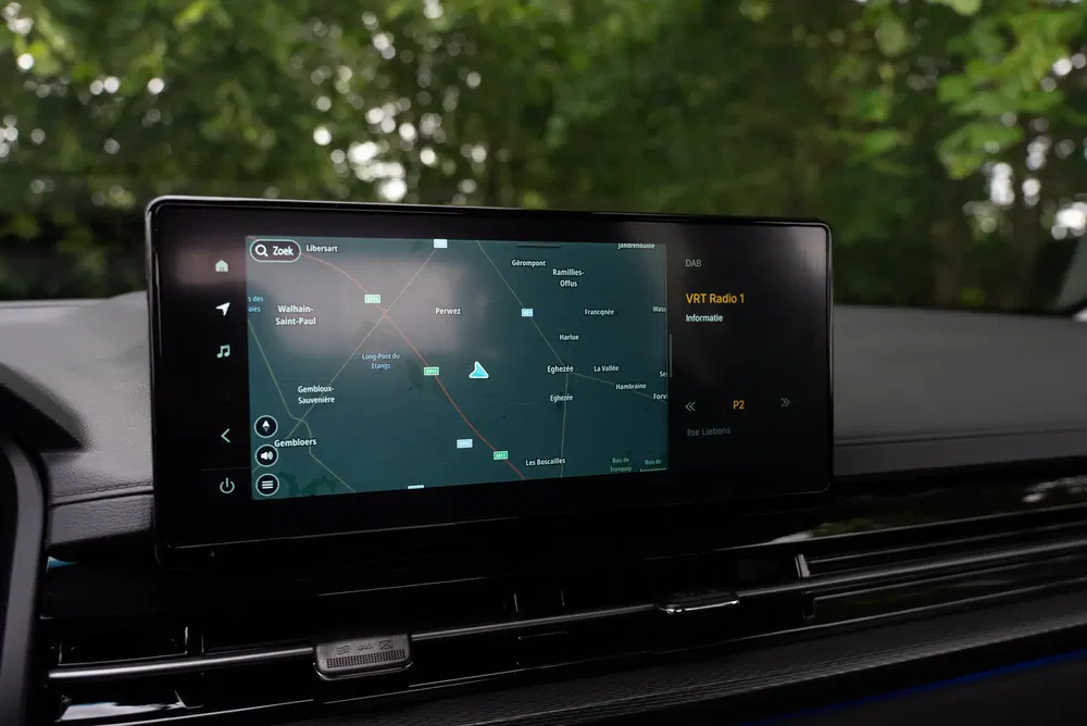 Écran d'affichage de navigation dans une voiture avec carte et services radio.