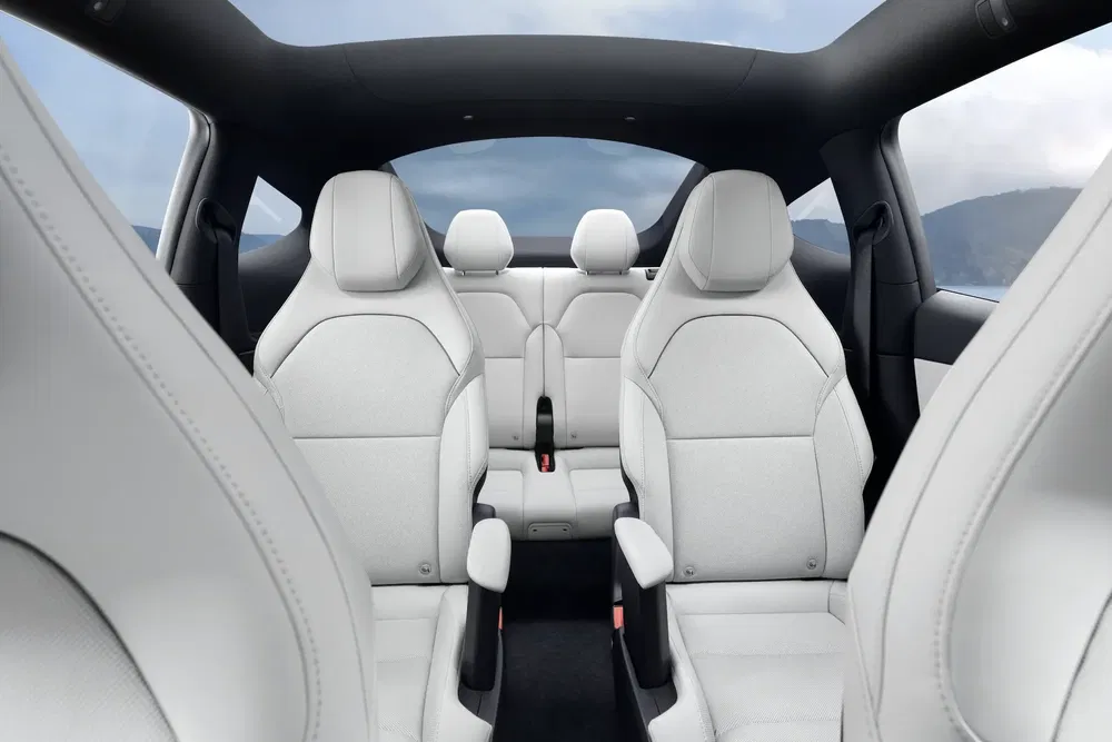 Intérieur de voiture Tesla Model X avec sièges en cuir blanc et toit panoramique.
