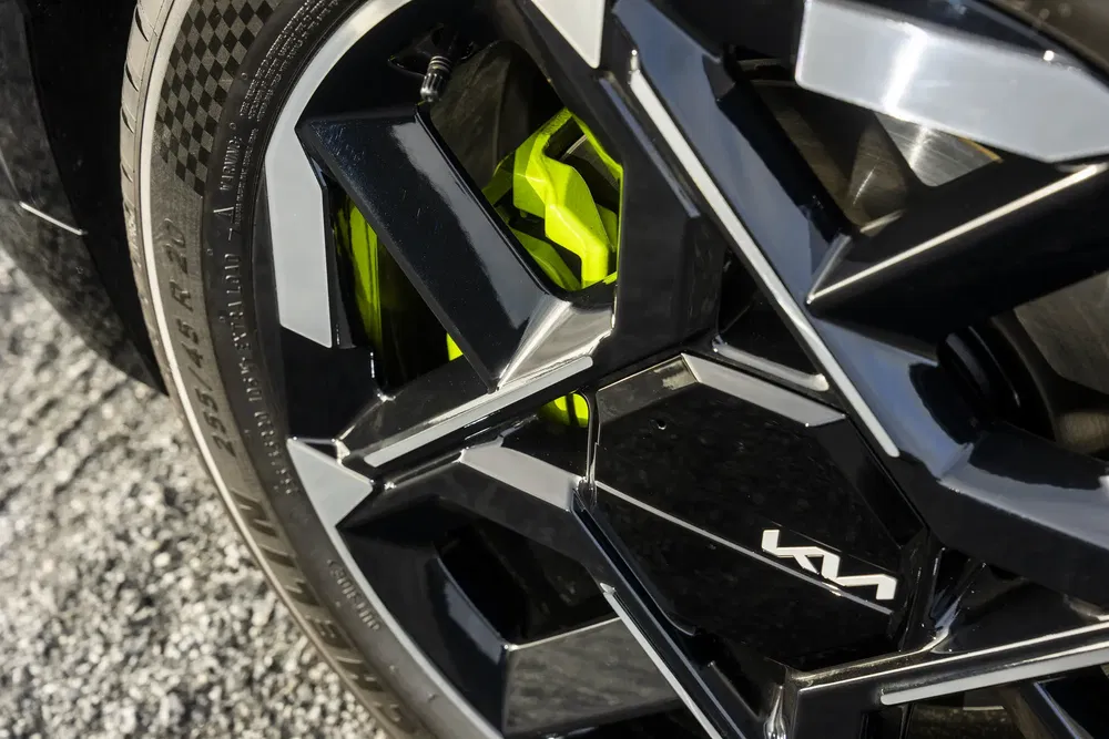 Gros plan sur une roue Kia avec jante noire et étrier de frein vert fluo.