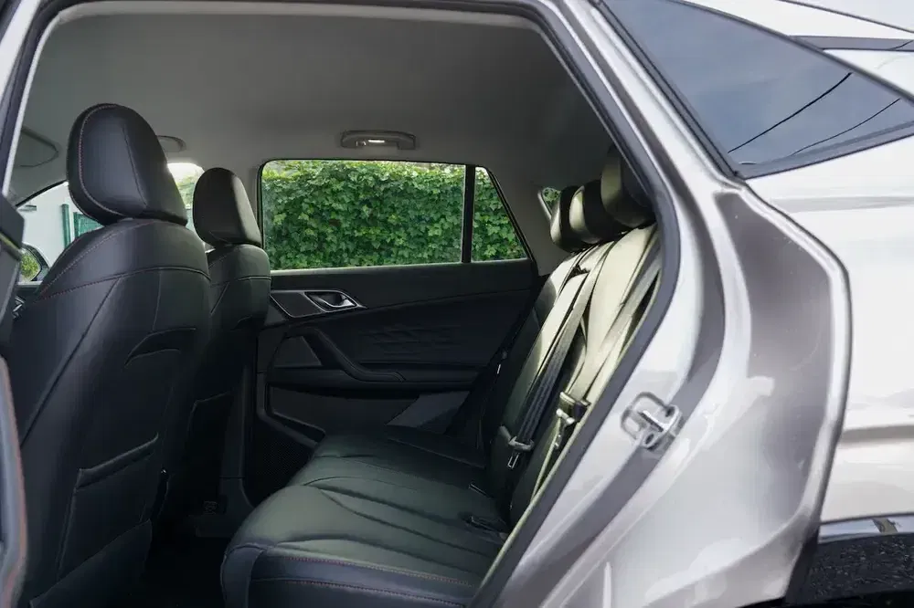 Achterzitplaatsen van een BMW SUV met zwart lederen interieur, zijaanzicht open.