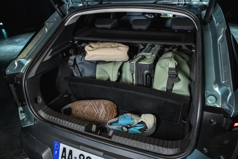 Ruime kofferbak van auto, georganiseerd met reistassen en sportschoenen.