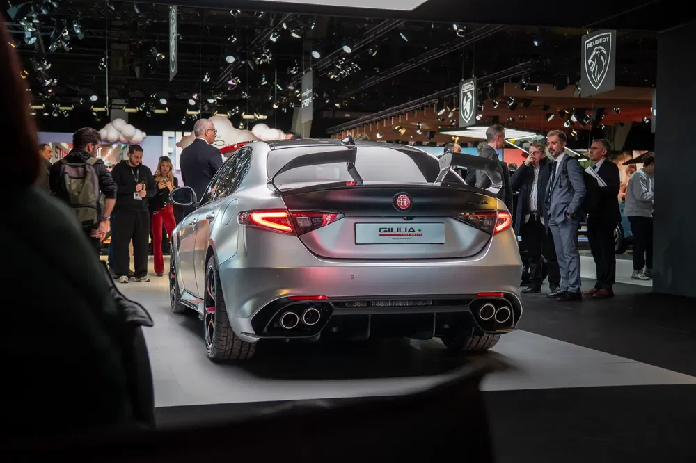 Alfa Romeo Giulia met spoiler, tentoongesteld voor menigte op een autosalon.