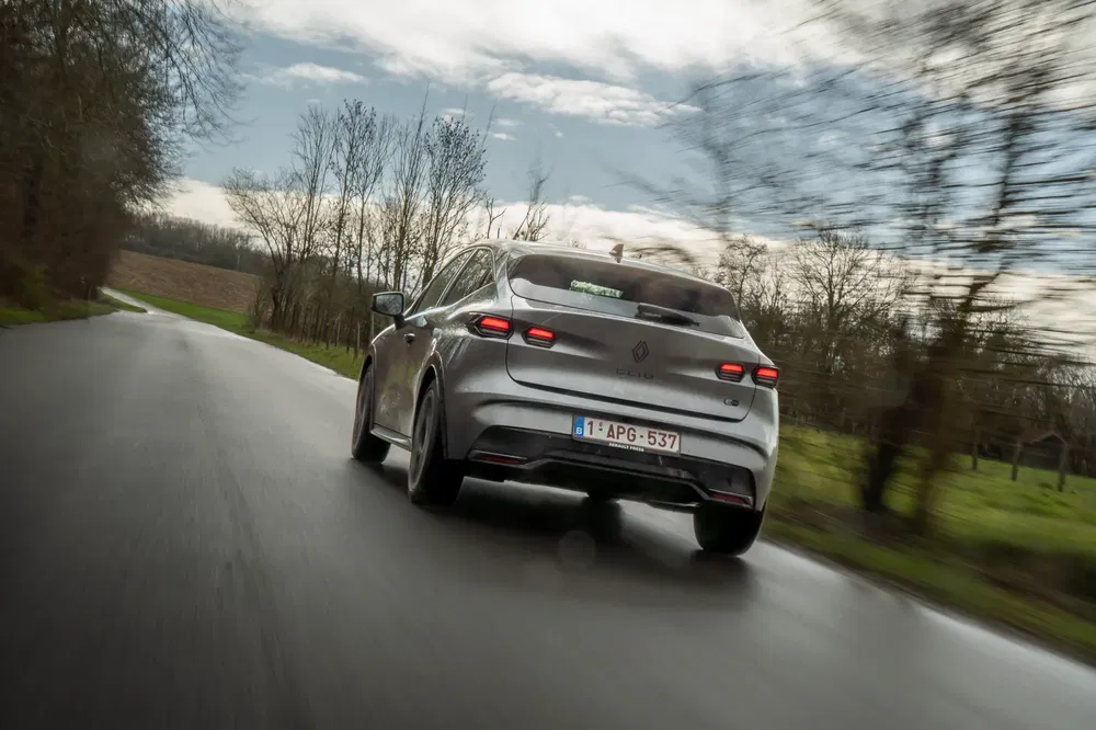 {"fr":"Renault Mégane électrique roulant sur une route de campagne bordée d'arbres.","nl":"Elektrische Renault Mégane rijdt op een boomrijke landelijke weg."}