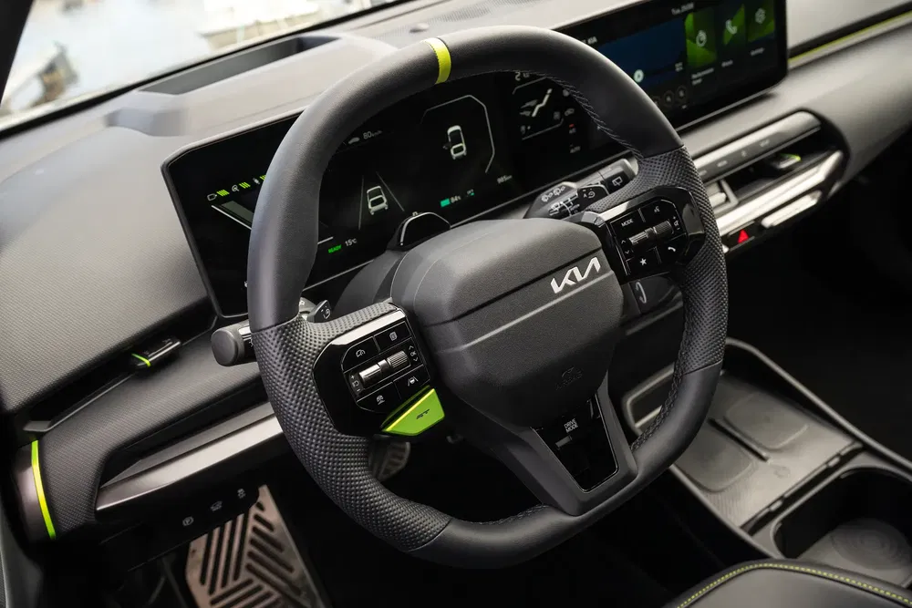 Volant de voiture Kia moderne avec écran numérique et finitions vert néon.