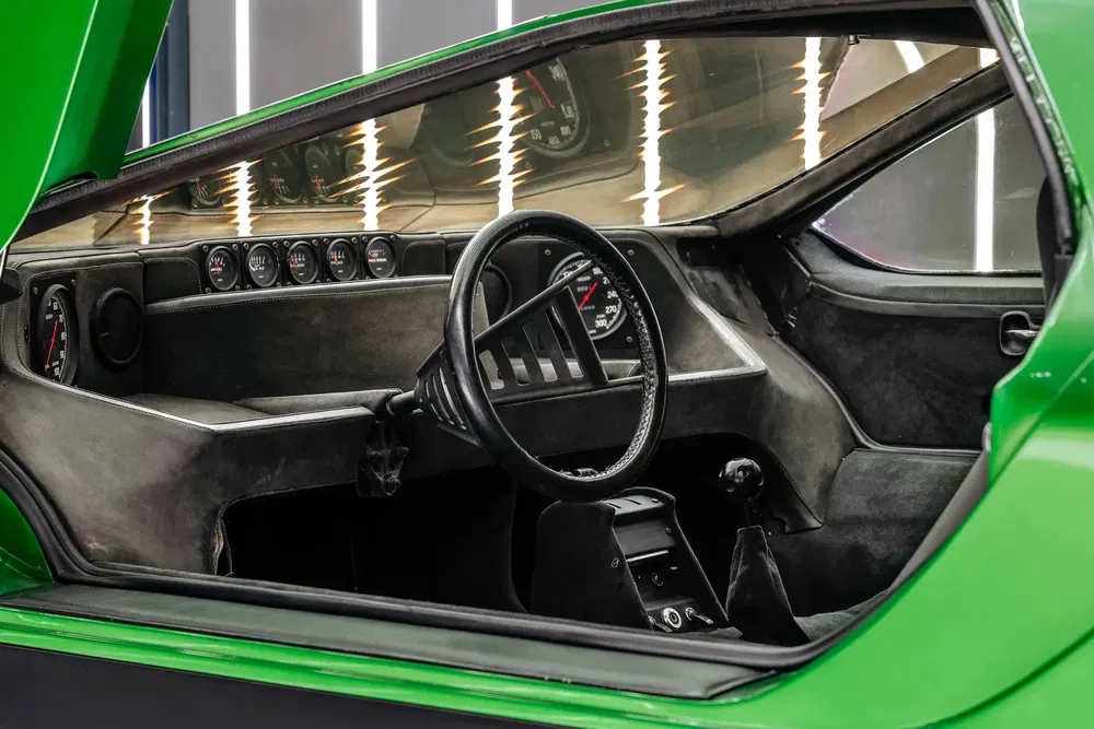 Intérieur de voiture vintage avec tableau de bord minimaliste et volant classique.