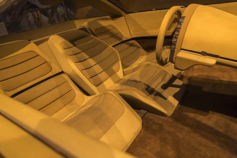 Retro-futuristisch interieur van een conceptauto met beige stoelen en dashboard.