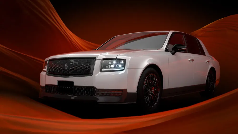 Witte Toyota Century met LED-verlichting tegen een dynamische oranje achtergrond.