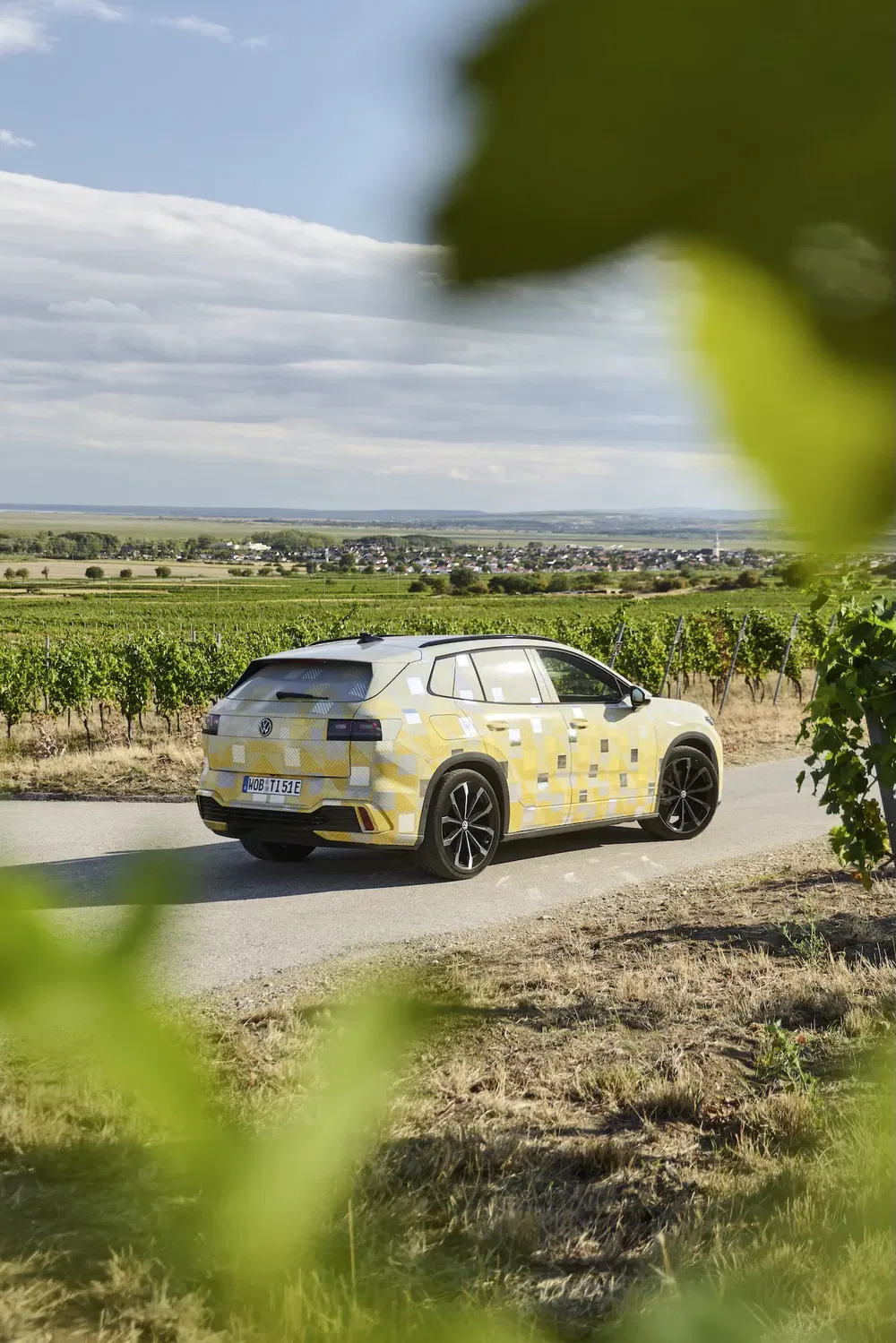 Prototype Volkswagen ID en test, roulant dans un paysage champêtre pittoresque.