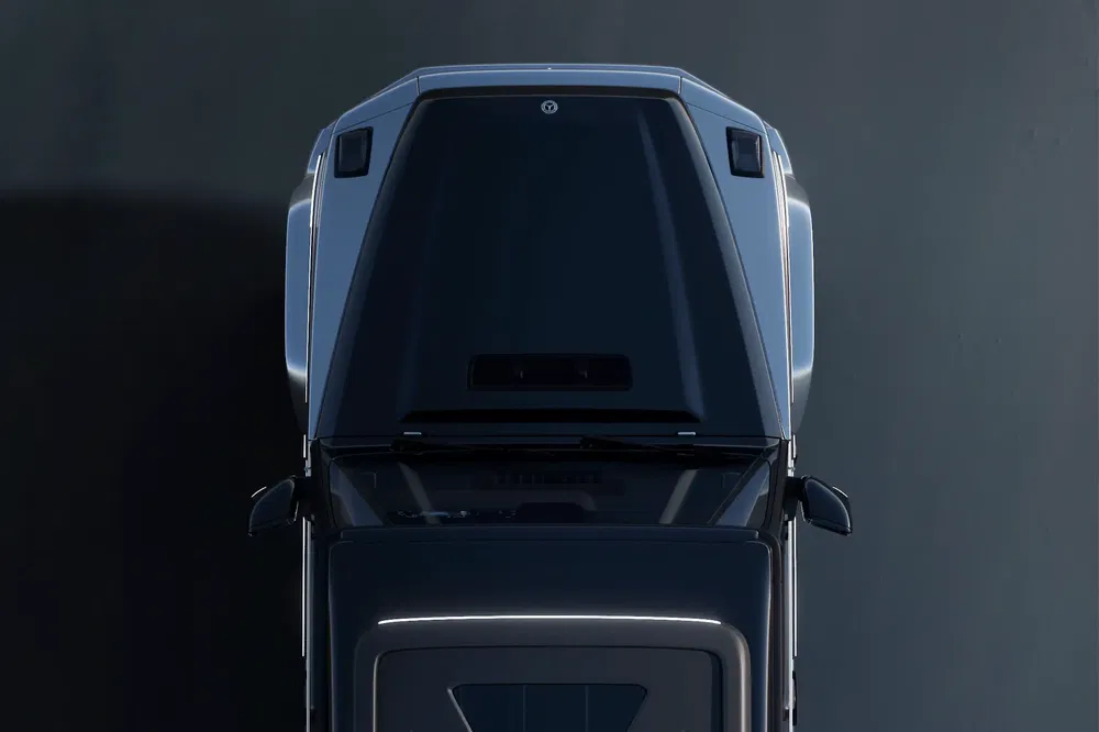 Vue aérienne d'un SUV Polestar en gris métallisé sur fond sombre.