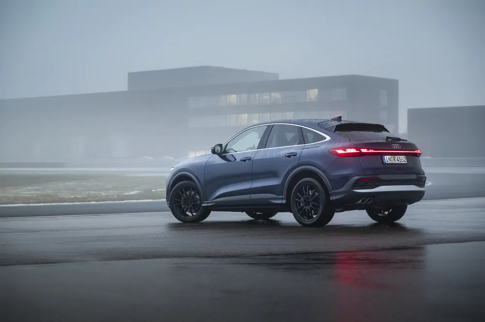 Audi Q5 SUV geparkeerd op mistige baan voor modern gebouw.