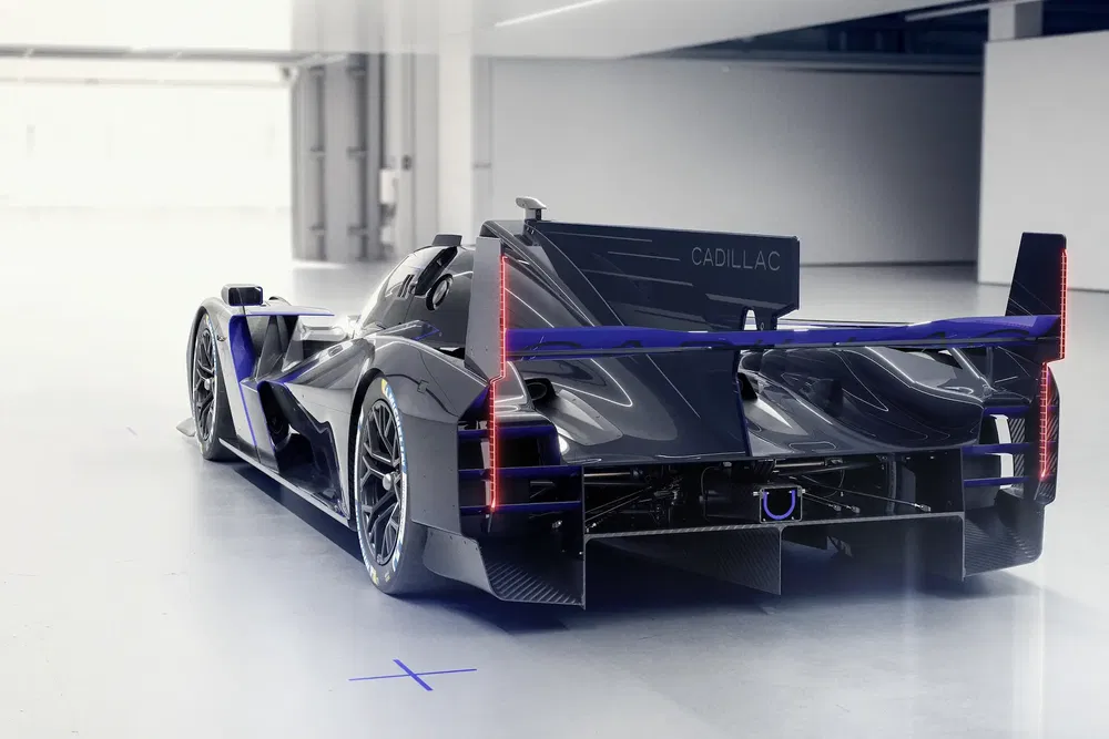 Prototype de course Cadillac noir moderne dans un garage spacieux.