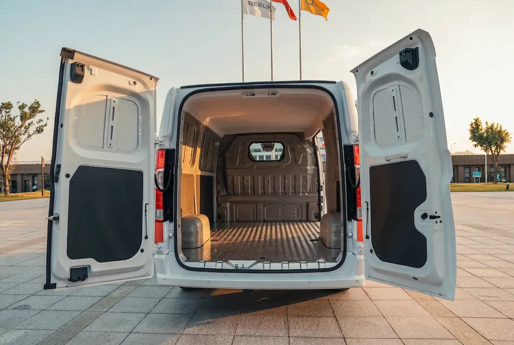 Witte bestelwagen met open achterdeuren, toont een lege en ruime laadruimte.