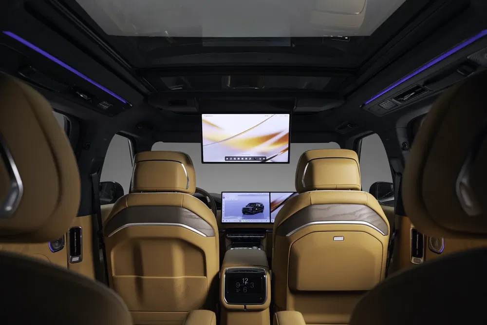Intérieur luxueux avec sièges en cuir et moniteurs dans un Range Rover moderne.
