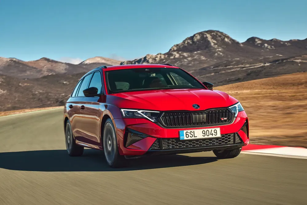 Skoda Octavia RS rouge sur circuit désertique, montagnes en arrière-plan.