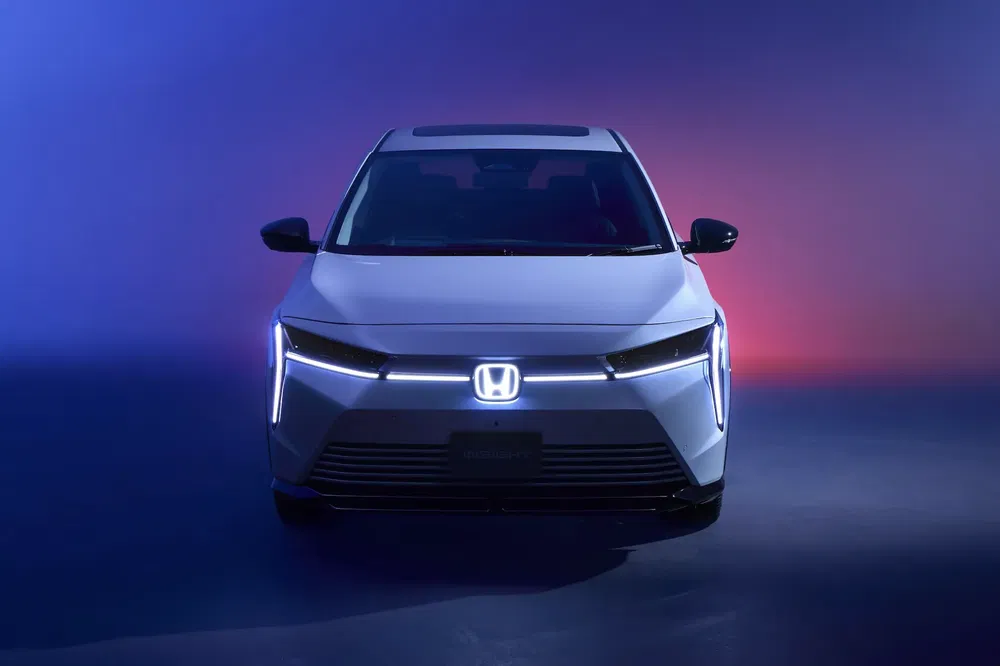 Vue avant de la Honda Prologue électrique avec phares LED distincts sur fond dégradé.