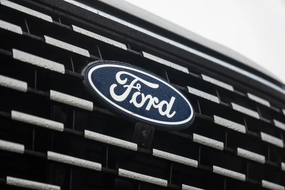 Gros plan du logo Ford sur une calandre de voiture moderne.