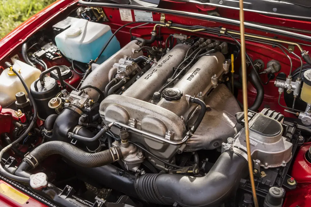 Moteur Mazda avec double arbre à cames 16 soupapes dans un compartiment rouge.