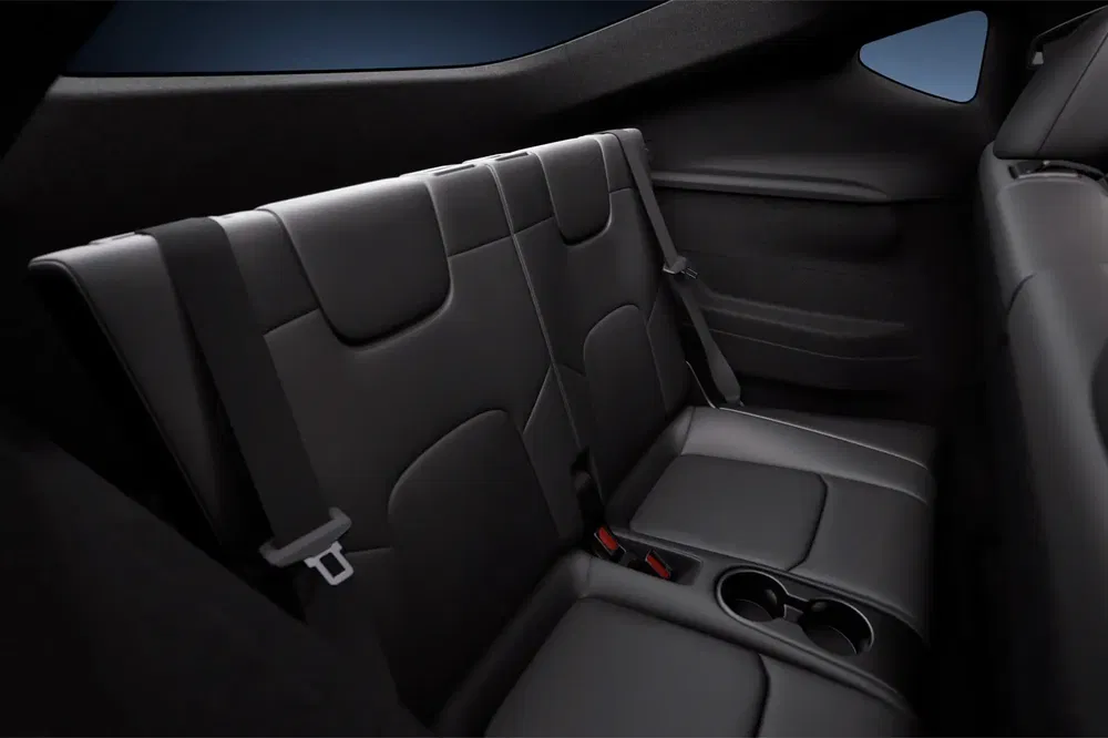 Sièges arrière en cuir noir d'un modèle de voiture Tesla avec porte-gobelets intégrés.