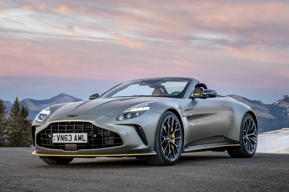 Aston Martin DBS Superleggera grise avec arrière-plan montagneux au coucher du soleil.