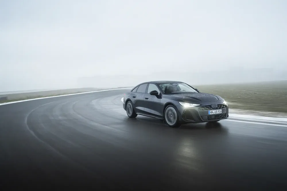 Audi A7 rijdt op een nat circuit onder een bewolkte hemel.