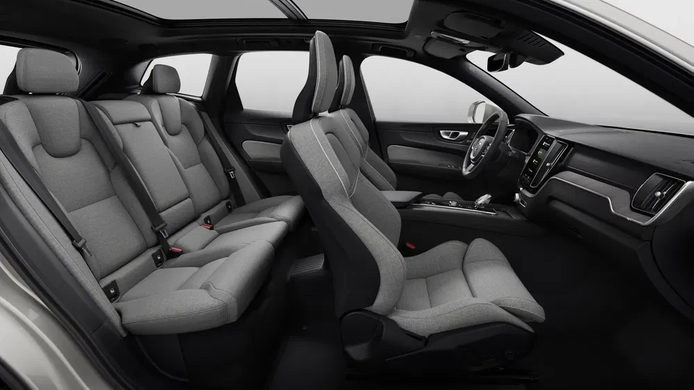 Ruim, modern interieur van Volvo XC40 met grijze stoffen stoelen en panoramadak.