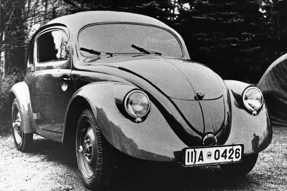Voiture classique Volkswagen Coccinelle noire des années 1930, vue de face en extérieur.