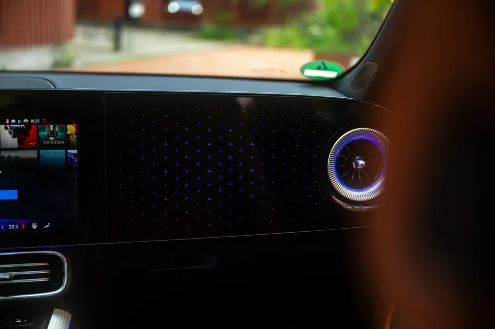 Moderne Mercedes-dashboard met digitaal scherm en futuristische sfeerverlichting.