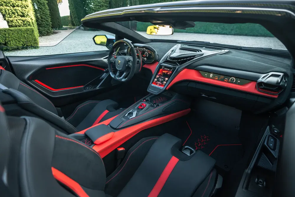 Interieur van een Lamborghini Revuelto met modern ontwerp, rode accenten en geavanceerde technologie.