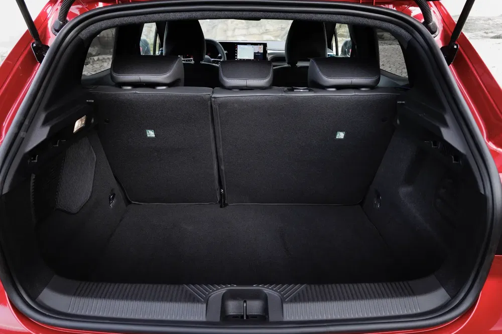 Coffre spacieux d'une Peugeot 308 rouge montrant capacité de chargement arrière.