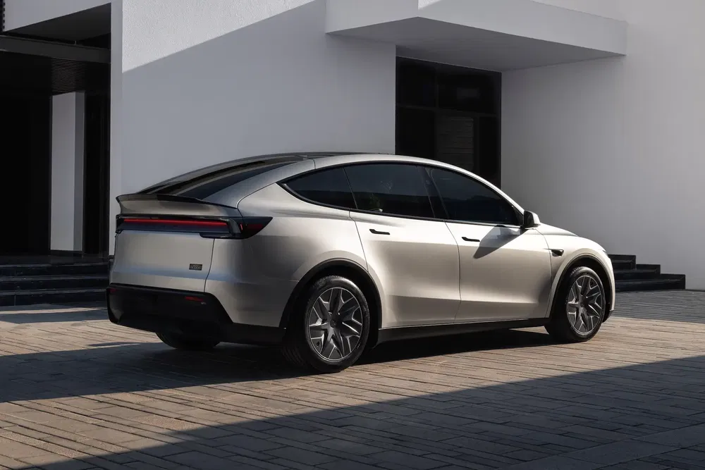 SUV argenté moderne garé devant un bâtiment minimaliste, design épuré et sophistiqué.