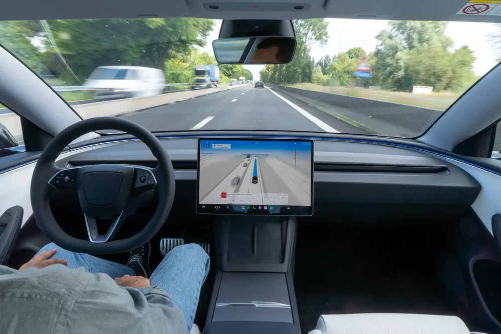 Voiture autonome sur autoroute avec tableau de bord numérique affichant la navigation.