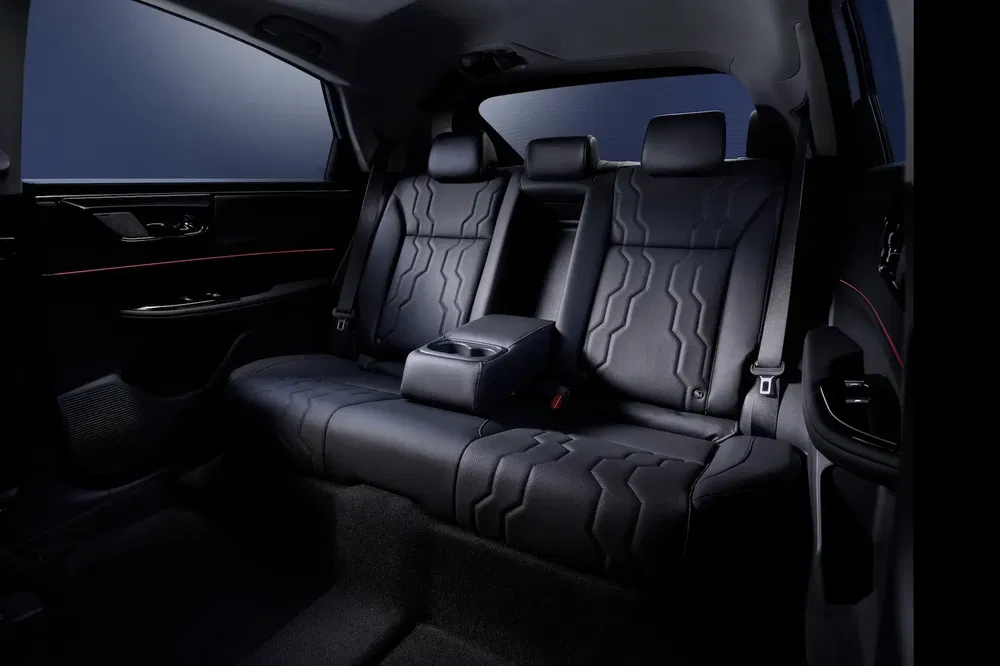 Intérieur de voiture de luxe, sièges arrière en cuir noir avec repose-bras central moderne.