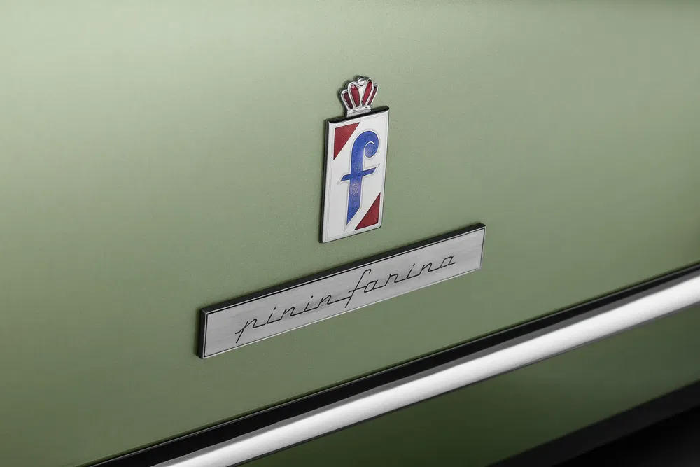 Logo Pininfarina sur une voiture vert olive emblématique, symbole d'élégance italienne.
