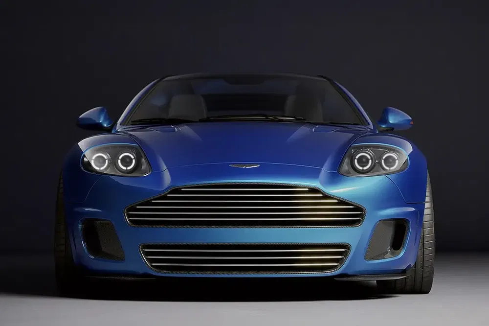 Voiture sportive Aston Martin bleue avec calandre distinctive et phares avant élégants.