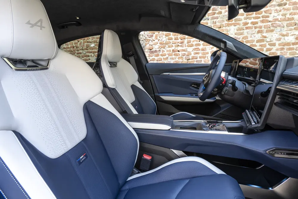 Intérieur de la voiture Alpine, sièges en cuir bleu et blanc, tableau de bord moderne.
