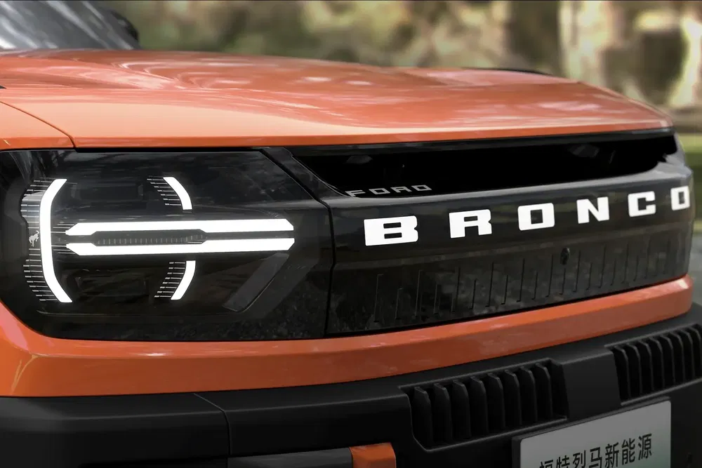 Gros plan sur la calandre du Ford Bronco orange avec phares LED distinctifs.