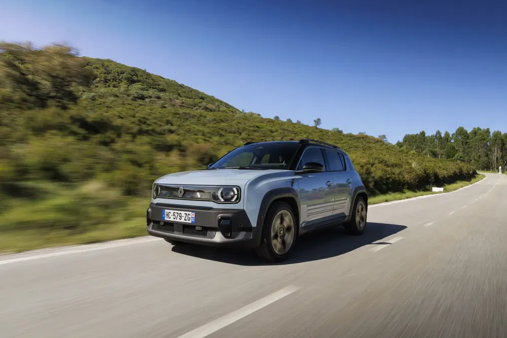 {"fr":"SUV électrique Renault 5 roulant sur une route rurale sous ciel bleu clair.","nl":"Elektrische Renault 5 SUV rijdt op een landelijke weg onder een heldere blauwe hemel."}