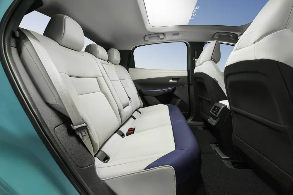 Ruim interieur van de MG Hector met witte lederen stoelen en panoramadak.