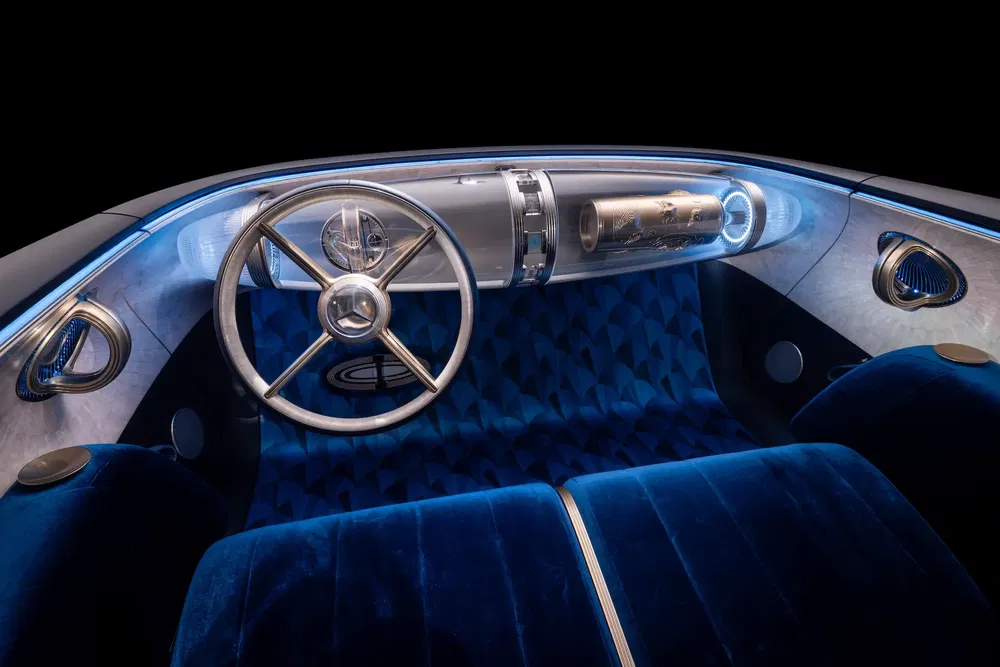 Retro-futuristisch auto-interieur met Mercedes stuur en stijlvolle blauwe fluwelen stoelen.