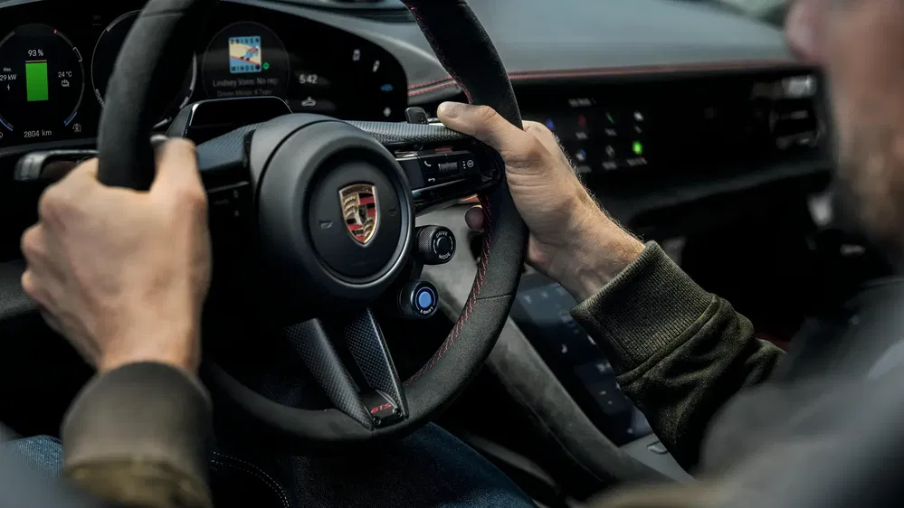 {"fr":"Intérieur d'une Porsche moderne avec volant et tableau de bord numériques visibles.","nl":"Interieur van een moderne Porsche met zichtbaar stuurwiel en digitaal dashboard."}