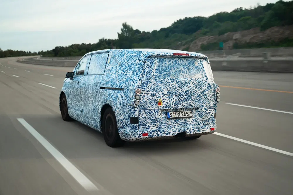 Prototype de van camouflé sur autoroute, testant de nouveaux designs de carrosserie en mouvement.