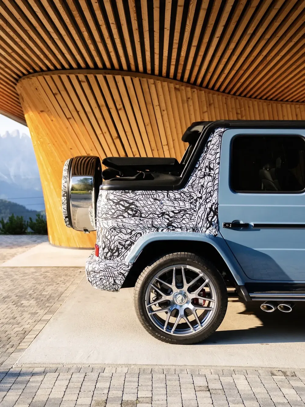 Mercedes-Benz G-Class partiellement camouflée, exposant ses jantes alliage et son arrière distinctif.