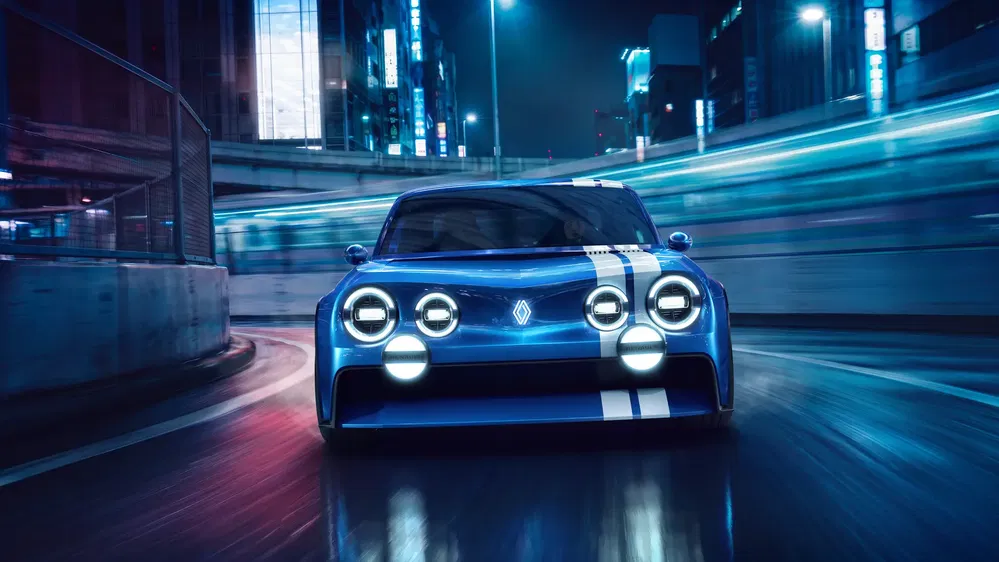 Renault concept car bleu dans une rue de ville illuminée la nuit.