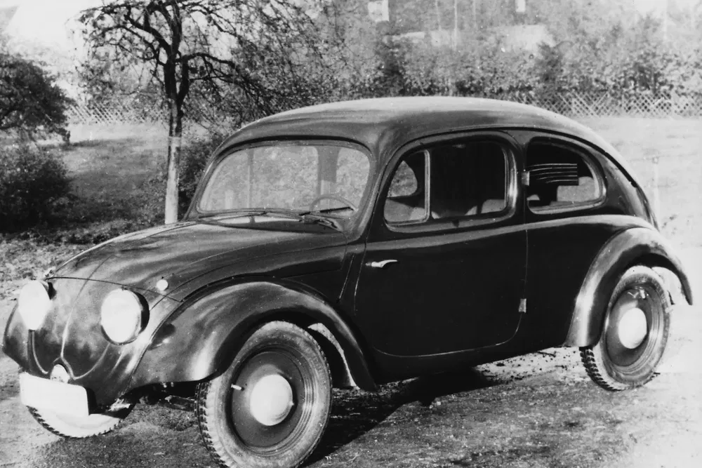 Prototype Volkswagen Beetle en noir et blanc, design arrondi classique et phares avant proéminents.