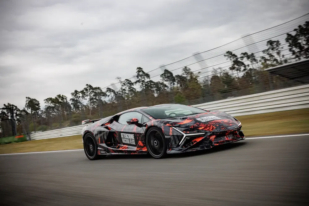 Lamborghini camouflée en test sur circuit, design agressif et aérodynamique.