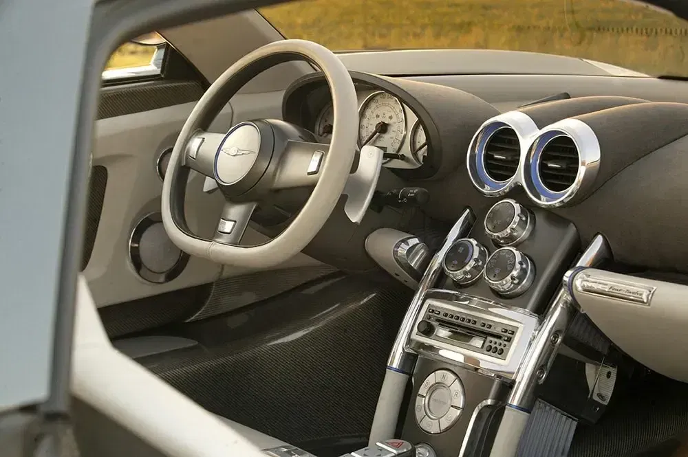 Chrysler auto-interieur met futuristisch dashboard en stuurwiel in geborsteld aluminium.