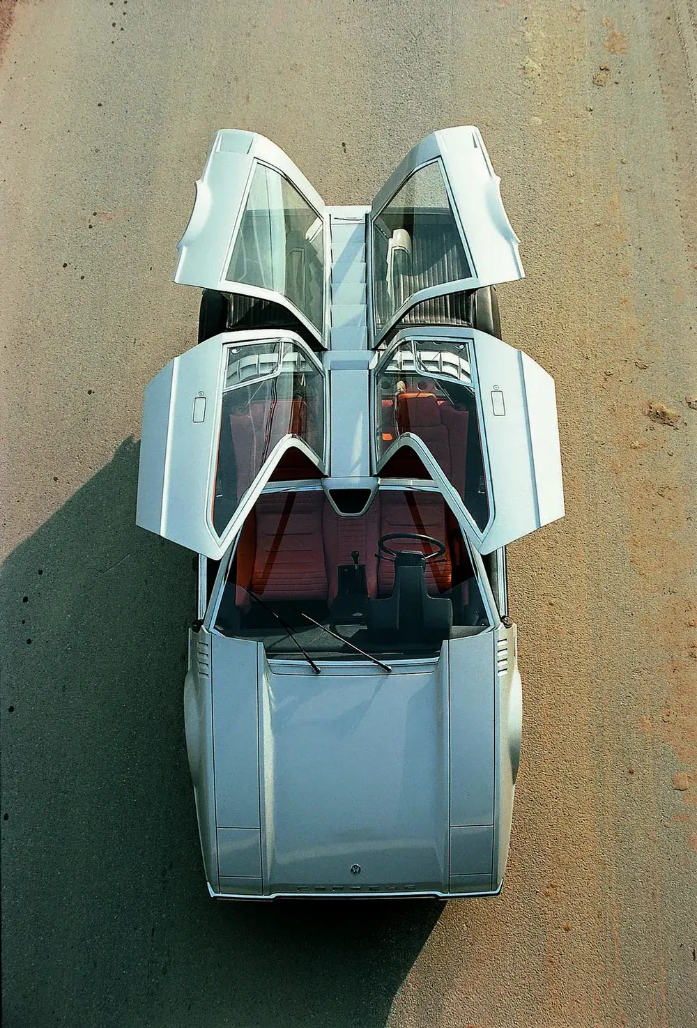 Concept car Lamborghini Marzal avec portes papillon ouvertes, intérieur orange, vue de dessus.