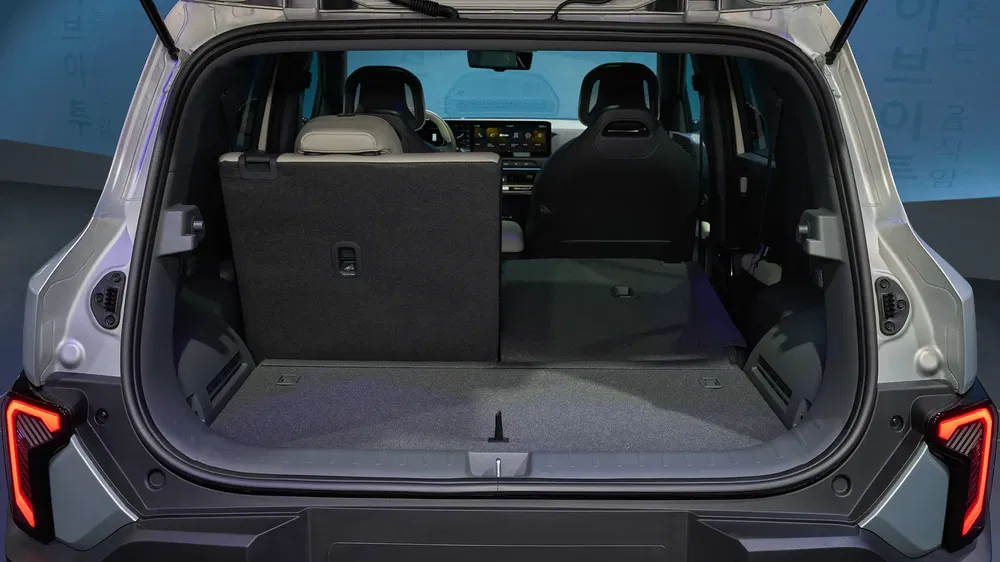 Coffre spacieux du SUV Hyundai Kona avec dossiers rabattus et sièges avant visibles.