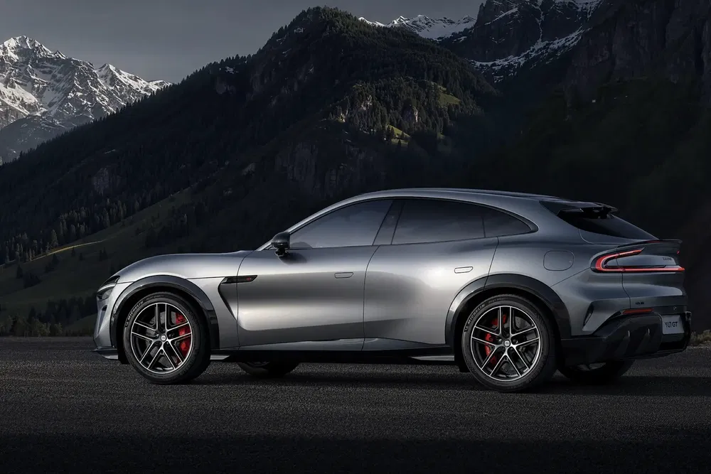 SUV électrique sportif argenté avec pneus avant rouges sur fond de montagnes enneigées.