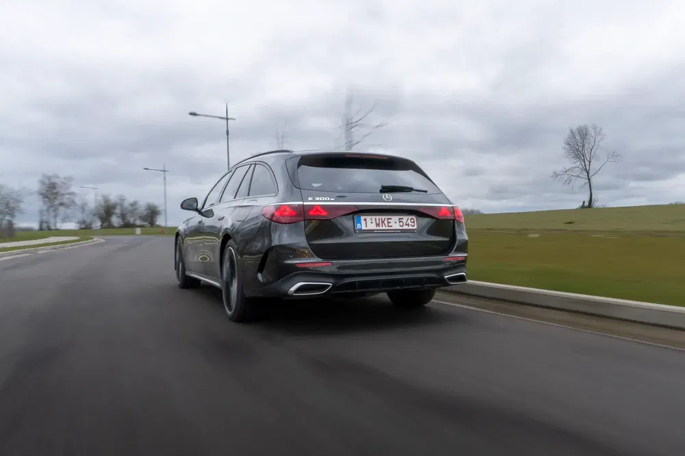 Mercedes-Benz break E 300d sur route de campagne, arrière dynamique jour nuageux.